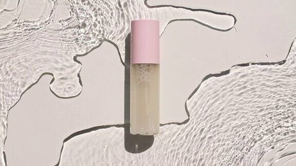 某保湿护肤品的广告化妆品瓶小瓶在水面上滴有阳光和影子的倒影的水缓慢运动的波浪水