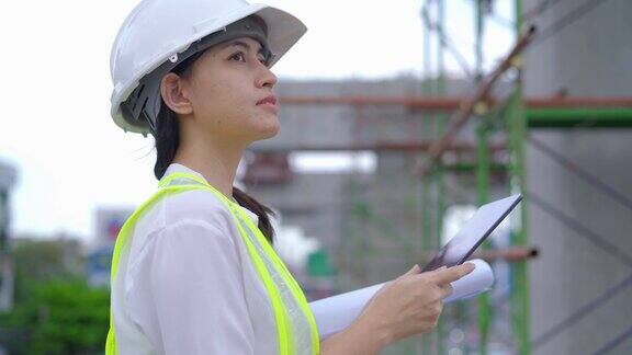 女土木工程师在工地用平板检查建筑师图纸
