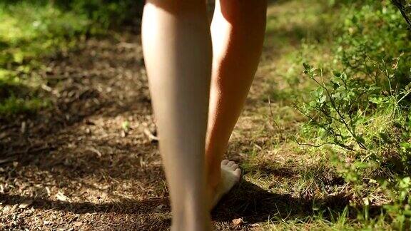 年轻女子赤脚走在森林里