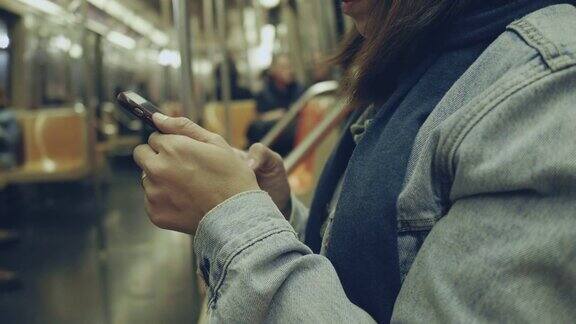 亚洲女性在地铁上使用智能手机