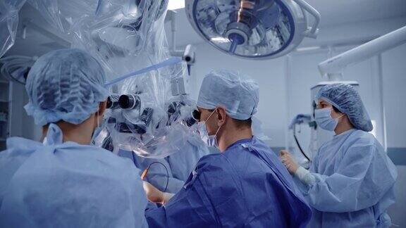 神经外科医生用显微镜身穿蓝色医疗制服的专业医生团队配合现代医疗设备进行神经外科手术