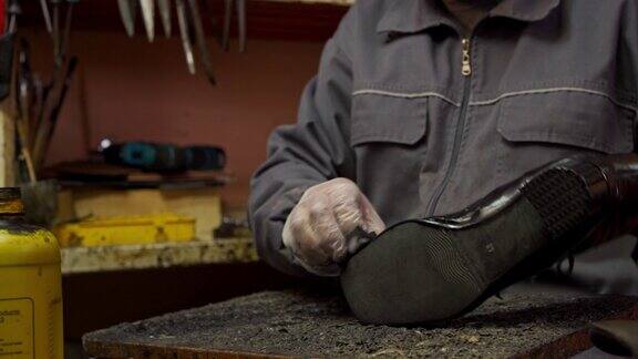 鞋匠在女式皮鞋的鞋跟上打洞并涂胶水