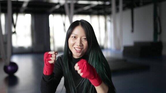 年轻的亚洲女拳击手在手指上缠着红色绷带练习拳击和格斗