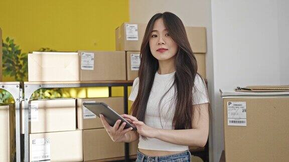 年轻的中国电子商务女员工在办公室使用触控板