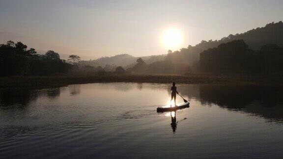 在泰国热带湖泊用桨冲浪