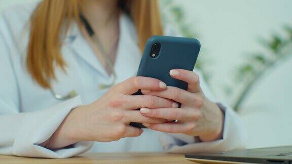 白大褂女医生使用现代智能手机触摸屏设备医生使用手机向患者发送短信告知医疗检查结果
