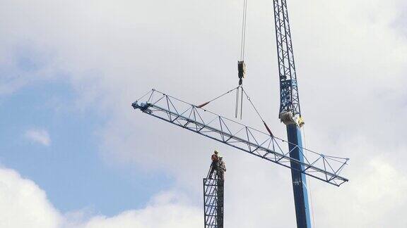 工人们在大高地安装起重机危险工作高塔建筑工人用绳结安全连接上的鹤