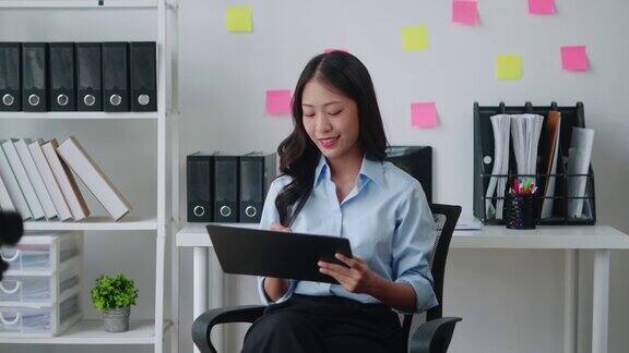年轻聪明的亚洲女商人一边在办公室工作一边分析文件