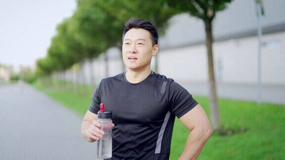 疲惫疲惫脱水的运动员跑步后喝水瓶