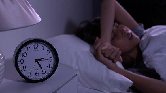 沮丧的年轻亚洲女性无法从失眠中入睡