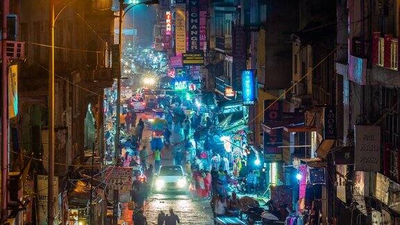 时间推移的主要集市街道显示霓虹灯招牌商店交通和行人在夜间在德里中心印度缩小