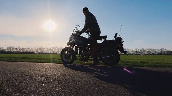 向前看去梦想和旅行一个骑摩托车的人手里拿着头盔走向摩托车