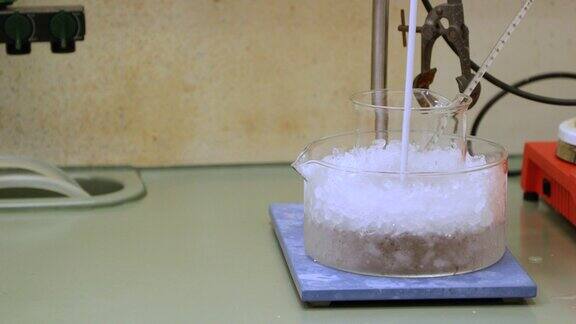 有温度计的烧杯中的化学溶液用冰冷却实验