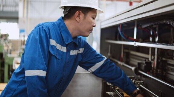 年轻的成年亚洲男性技术工程师检查制造机器在工厂工作技术维修工程物流行业业务工业岗位或人在工作