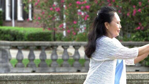 年长的亚洲女人在公园里练太极