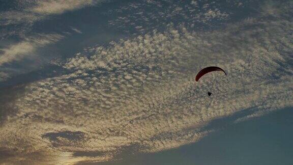 慢动作拍摄的动力滑翔伞在天空中飞行在日落