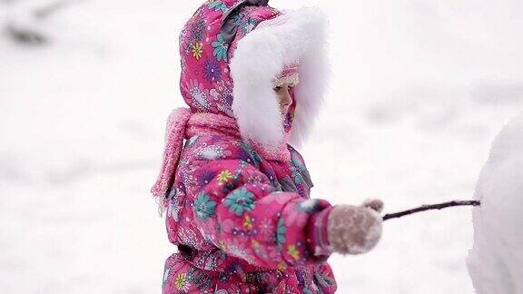 女孩冬天在雪地里堆雪人