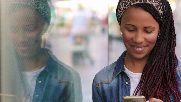年轻女子站在城市街道上使用智能手机