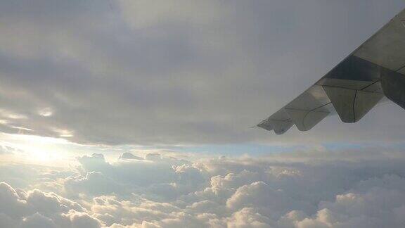 从飞机窗口的观点在机翼上的太阳在云