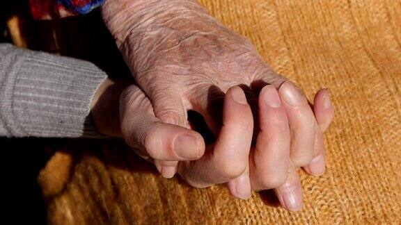 一位年轻女性的双手安慰着一位老人的双手老奶奶的双手在户外靠近