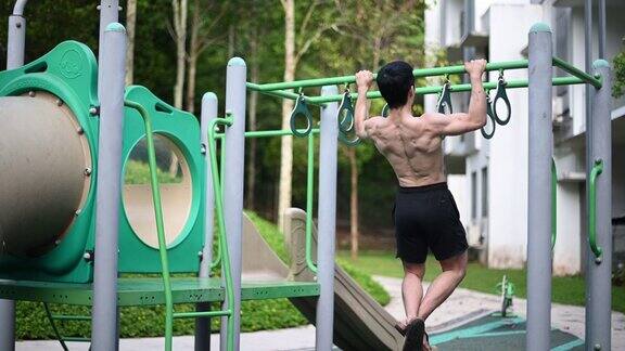 背部的亚洲华人男性运动员赤裸上身肌肉在操场上锻炼