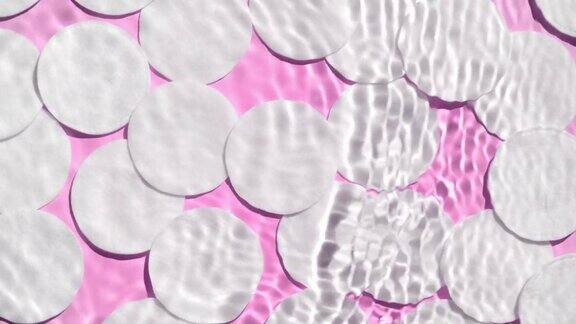 波浪溅在水面上的棉花垫在粉红色bg