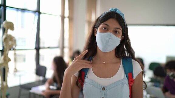 快乐的少女戴着防护口罩在学校