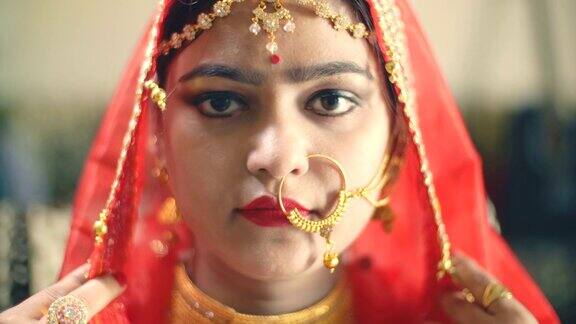 美丽的印度新娘穿着传统服装看着镜头