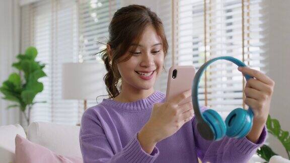 年轻的亚洲女性在社交媒体应用程序上录制视频评论产品