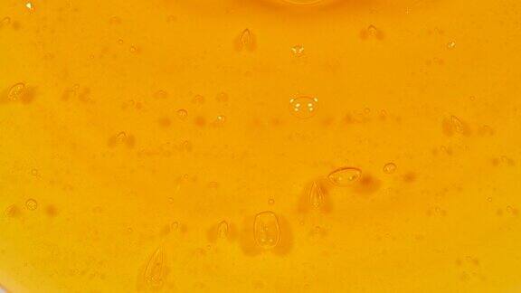 橙色精华化妆品凝胶美容透明霜沐浴露洗发水或液体与泡沫在白色的背景天然有机化妆品、药品微距拍摄生产特写