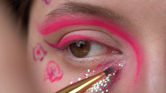 化妆刷在眼睛下面涂粉红色化妆品的特写镜头女性做舞台化妆