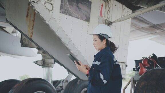 女飞机工程师使用数码平板电脑检查飞机