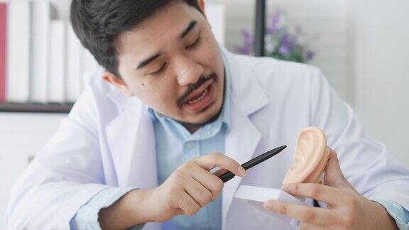 专业耳鼻喉科医生的慢动作场景抓拍视图通过在办公室远程医疗程序对耳膜症状进行解释和诊断