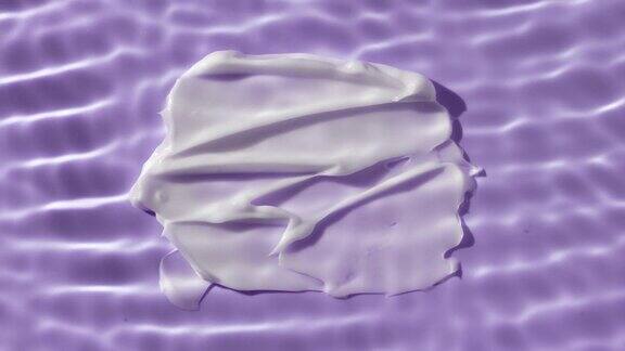 白色身体霜涂抹在紫色背景下的水波纹