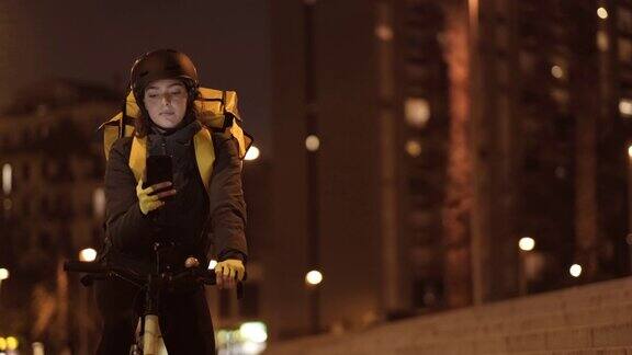 一个女自行车邮递员在城市工作到很晚