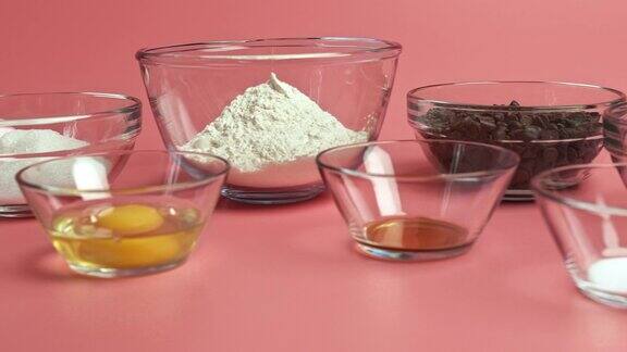 粉底玻璃碗中的巧克力饼干配料:红糖、白糖、巧克力片、鸡蛋、面粉、黄油、香草精、小苏打、4K盐