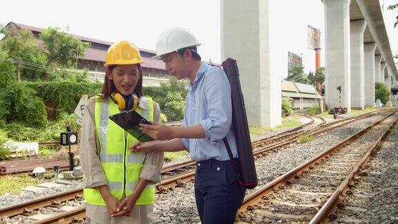 两名男工程师和女检查员工人讨论空中通行证列车轨道