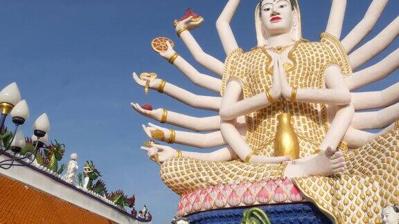 佛寺院子里的观音像观音多臂雕像坐落在传统佛教寺庙的院子里映衬着东方国家的万里无云的蓝天窟Plai岬苏梅岛