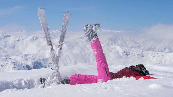 滑雪者把雪抛到空中抬起她的腿然后在雪中摔倒