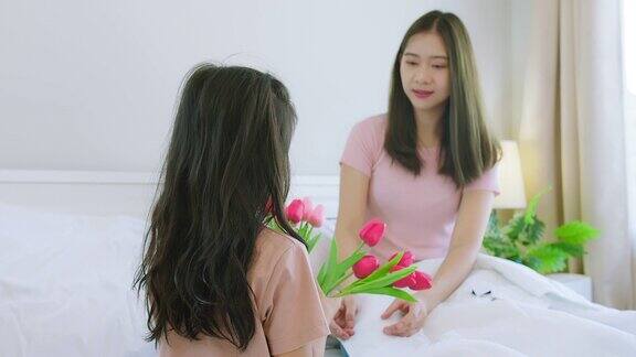 快乐的亚洲家庭可爱的孩子孩子女儿女孩祝贺母亲节感恩的妈妈捧着花在一起的时间在家里的卧室