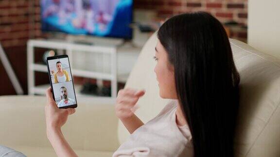 亚洲人在家远程工作同时通过数字视频电话会议与朋友交谈