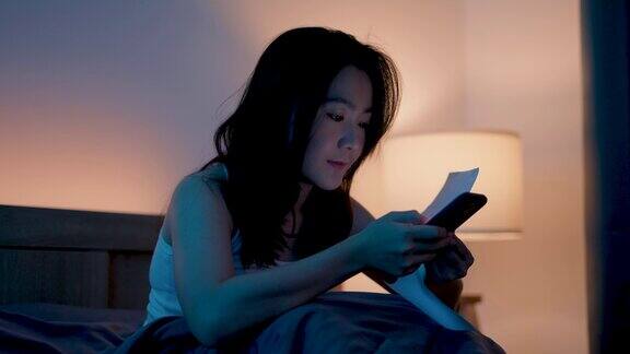 亚洲女性用智能手机扫描二维码支付账单轻松在家在线支付