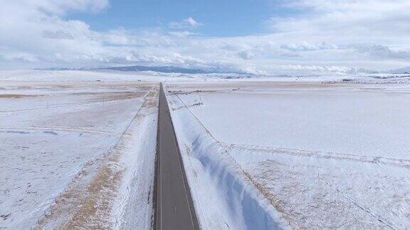无人机:沿着一条长长的直路飞行穿越寒冷的蒙大拿州