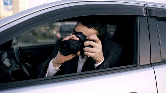 年轻私家侦探坐在车里用单反相机拍照