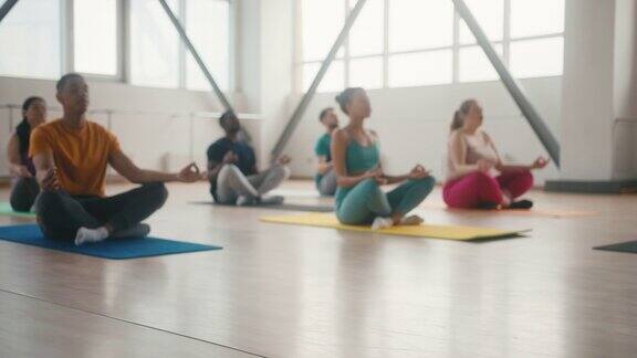 人们在健身房里的初级瑜伽课上冥想