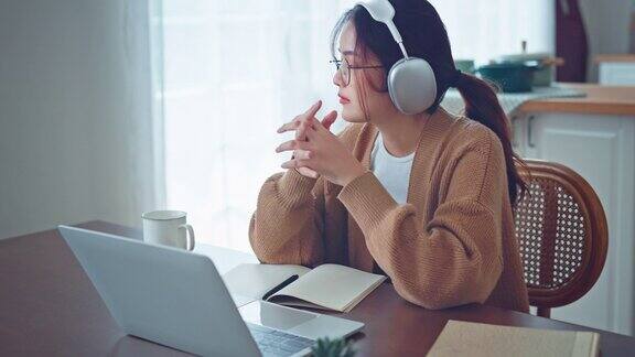 心烦意乱的亚洲女性看着笔记本电脑屏幕悲伤的女性工作笔记本电脑担心的女士压力在自由职业者在家里工作的工作场所