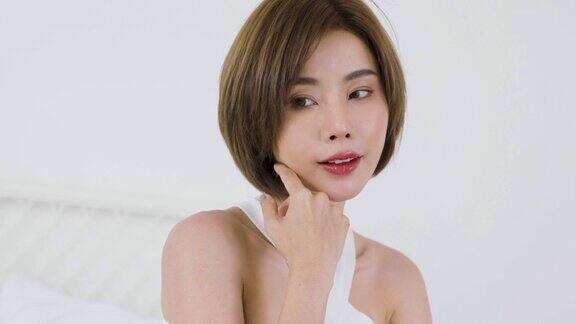 肖像美丽微笑的亚洲妇女在她的早晨例行程序应用乳液触摸皮肤可爱的亚洲女孩护肤身体乳美容诊所护肤水疗室内女性生活理念