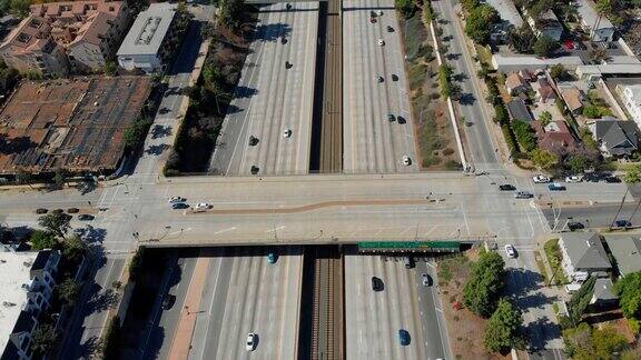 空中拍摄低空飞过210高速公路在帕萨迪纳加州与火车轨道房屋和高速公路标志在视野