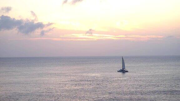 在开阔的海面上美丽的日落背景上的帆船