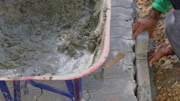 石匠在混凝土混合物上对齐水泥砖
